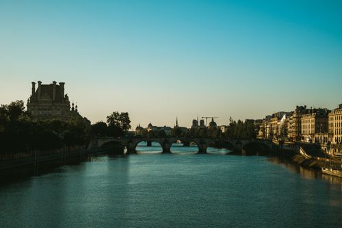 Free Beautiful view of the Seine River with a Parisian bridge during twilight, capturing iconic architecture. Stock Photo