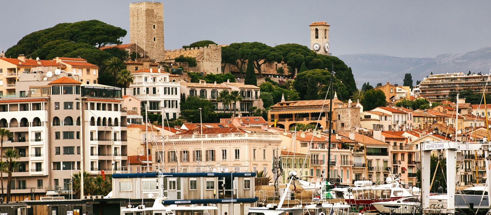 Beautiful harbor scene in Cannes showcasing historic buildings and vibrant waterfront activities.