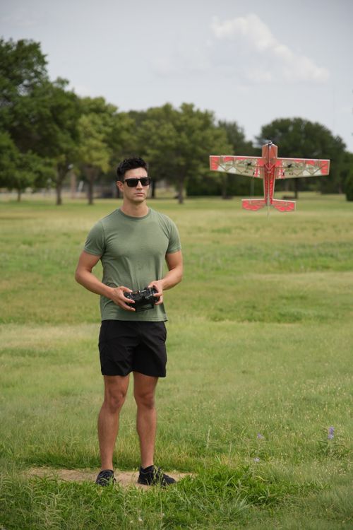 Free A man controls a remote airplane in a sunny Wichita Falls park. Stock Photo