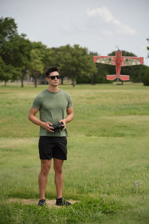 Free Man in a park flying a small remote-controlled plane on a sunny day in Wichita Falls. Stock Photo