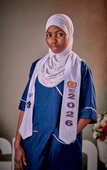 Portrait of a young Nigerian student in a graduation outfit with a hijab and a class sash reading 'SET 2026'.