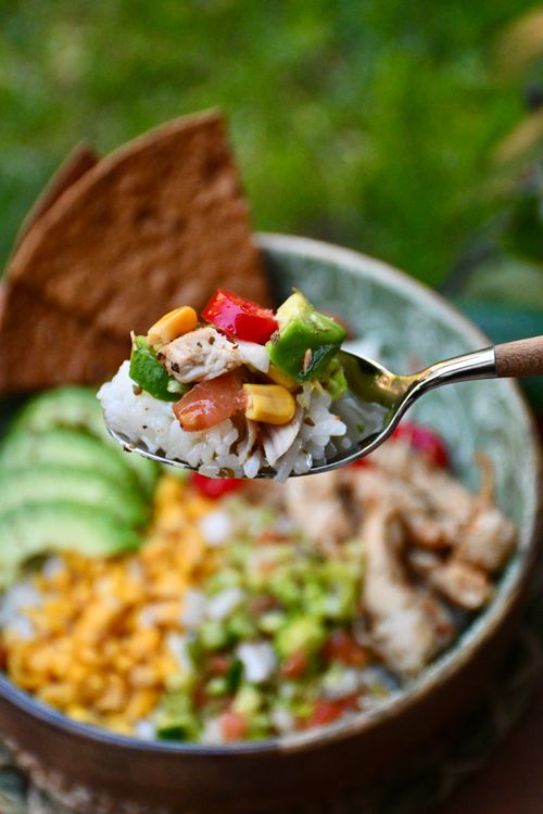 Free Close-up of a spoonful of Mexican rice with vibrant vegetables highlighting avocado, corn, and tomato. Stock Photo