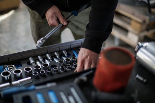 Free Crop mechanic choosing metal tools for repair in garage Stock Photo