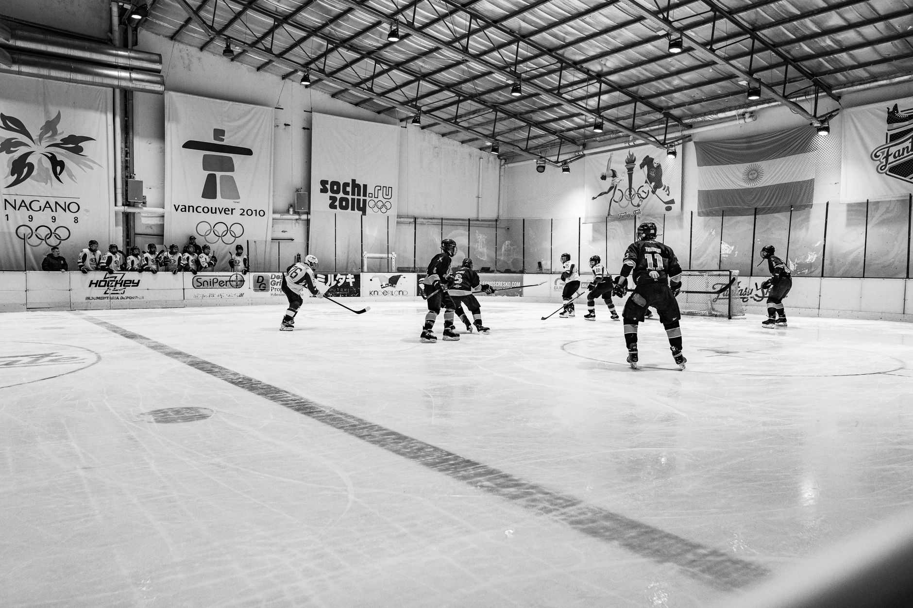 Black and white image capturing an intense ice hockey match at an indoor rink in Buenos Aires, Argentina.