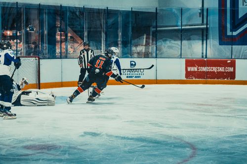 Free Exciting ice hockey scene capturing a high-energy match in Buenos Aires with players and referee in action. Stock Photo