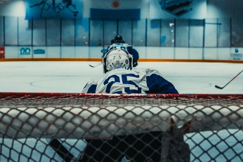 Free Ice hockey match in Buenos Aires arena featuring a focused goalkeeper behind the net. Stock Photo