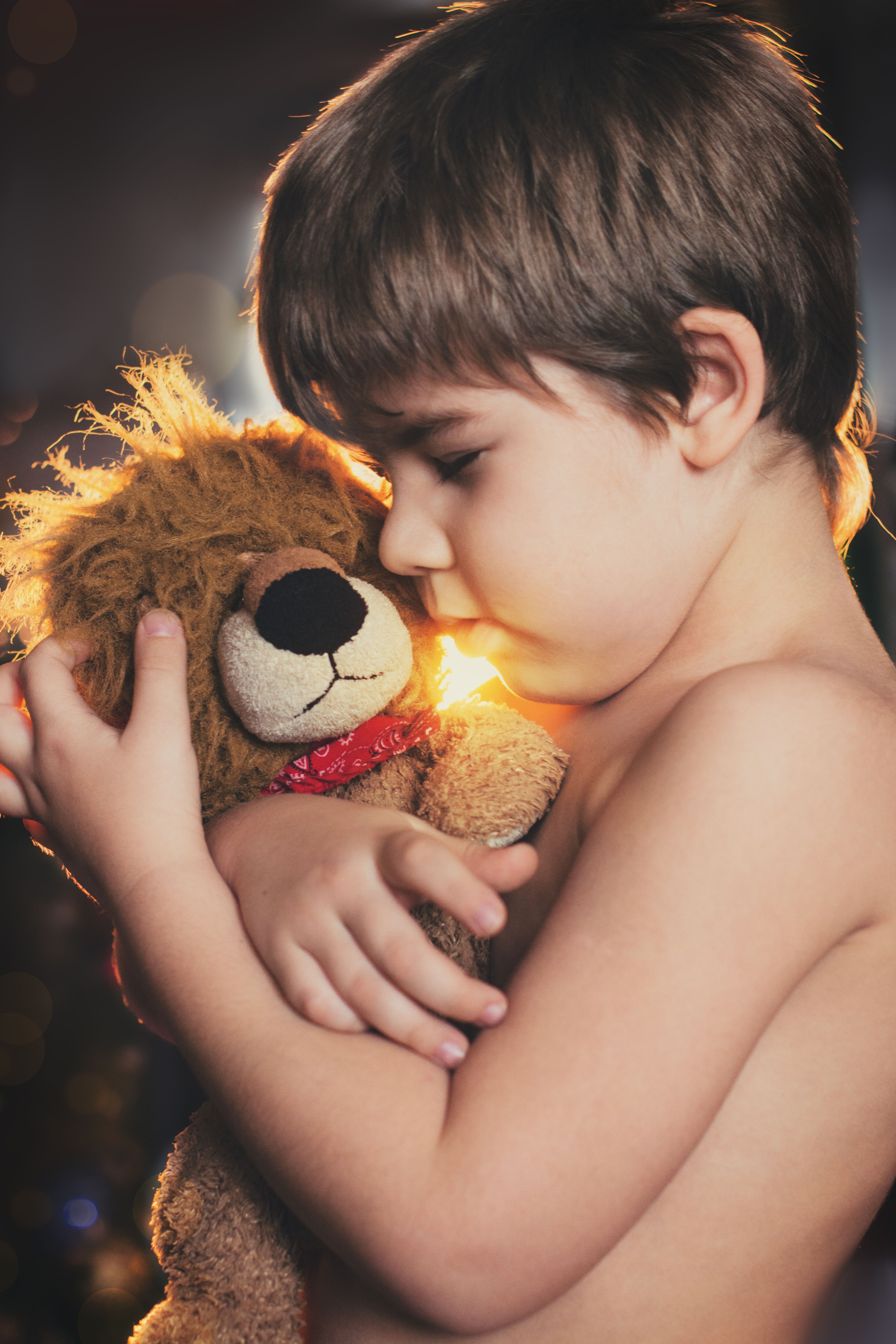 boy holding brown bear plush toy