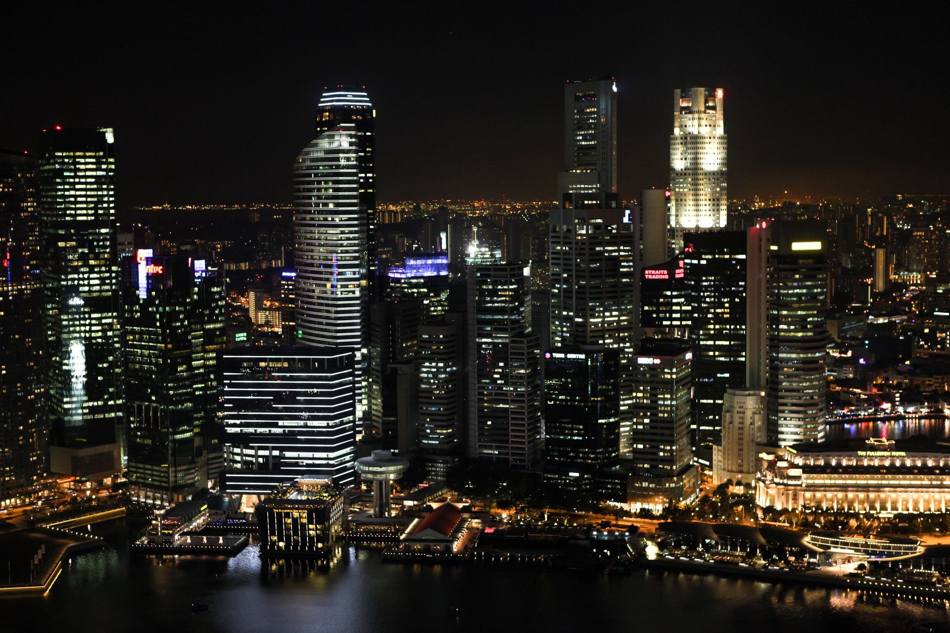 A breathtaking view of a city skyline at night with illuminated skyscrapers reflecting on the river.