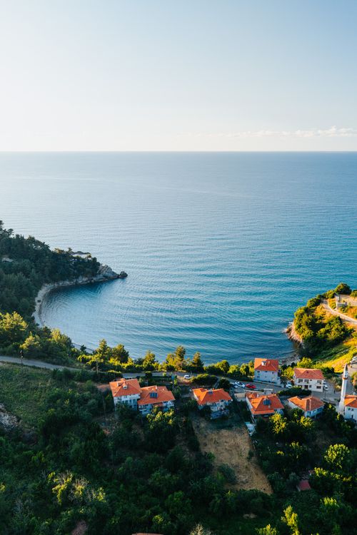 Free Scenic aerial view of a Mediterranean coastal village with red roofs near the sea. Stock Photo