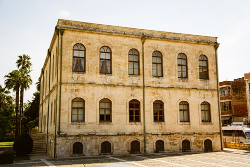 Free Vintage stone building with arched windows in Adana, Türkiye, capturing a classic architectural style. Stock Photo