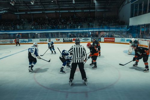 Free Exciting ice hockey face-off at an indoor arena in Buenos Aires with teams in action and full audience. Stock Photo