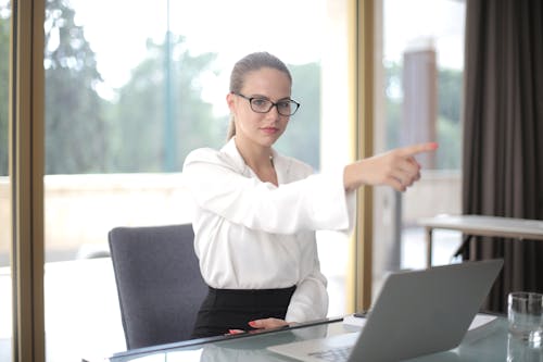 Serious businesswoman pointing away in office
