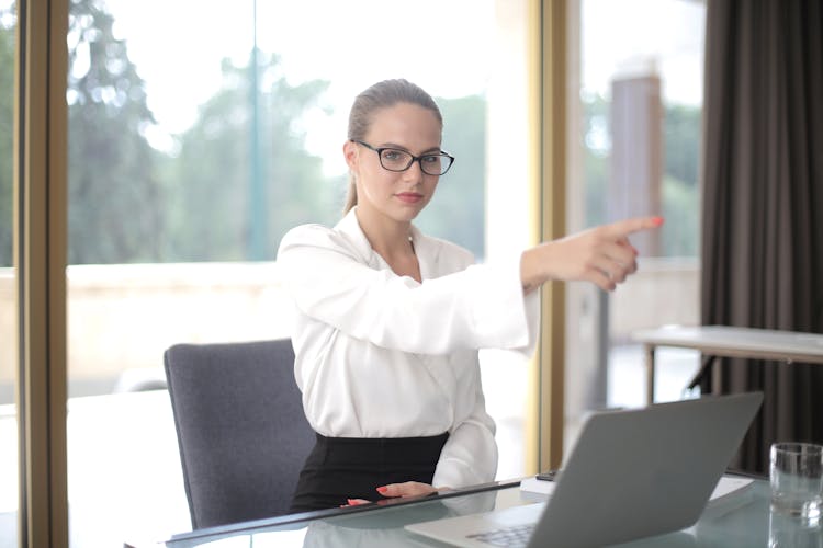 Serious Businesswoman Pointing Away In Office