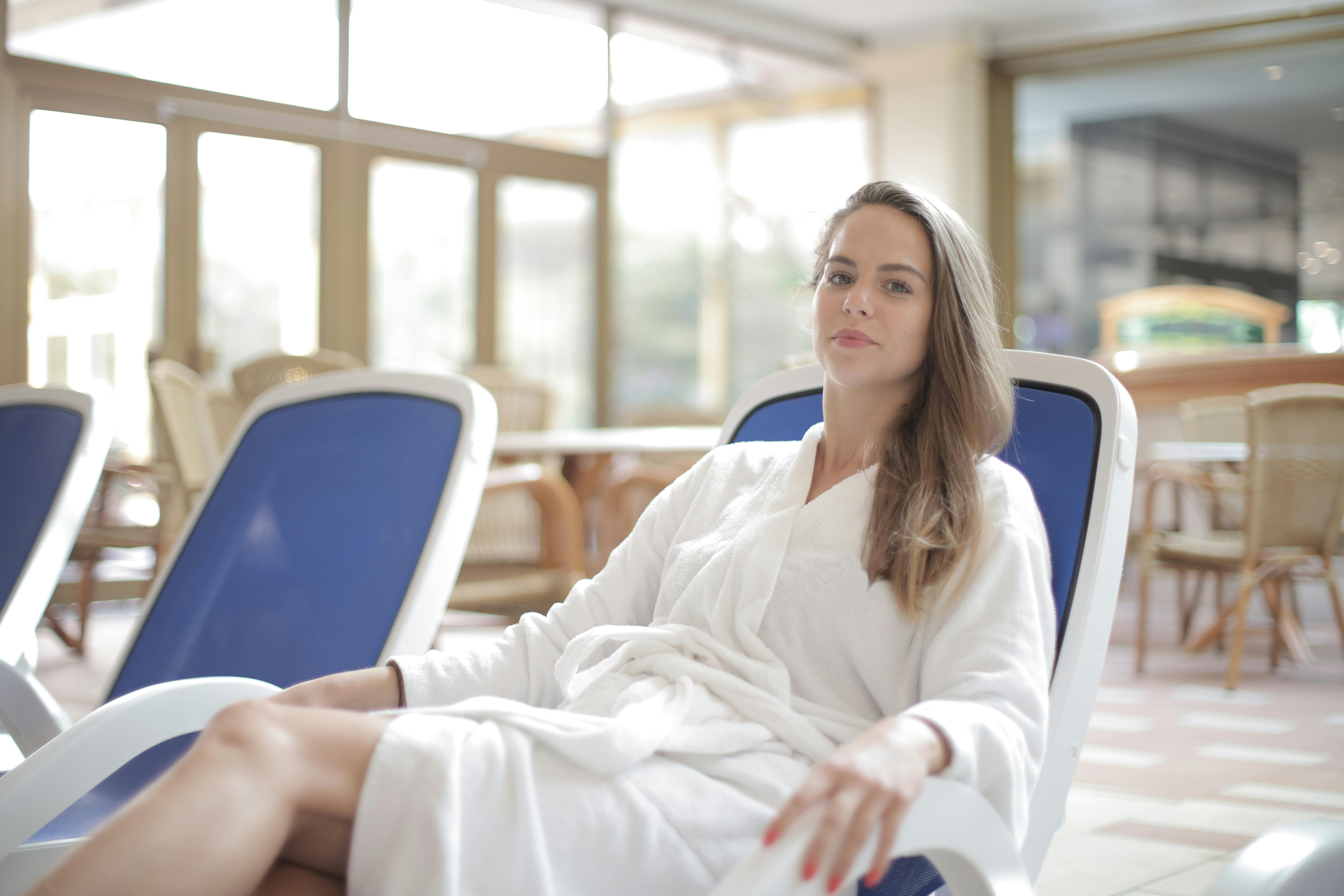Woman relaxing in a white spa robe at a luxury wellness retreat