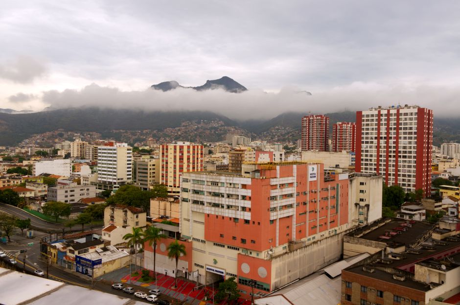 Captivating aerial view of Caracas with urban skyline and misty mountains in the background.