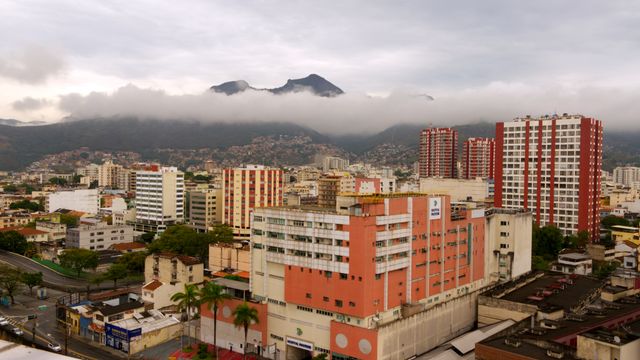 Captivating aerial view of Caracas with urban skyline and misty mountains in the background. — lounges at Caracas Airport