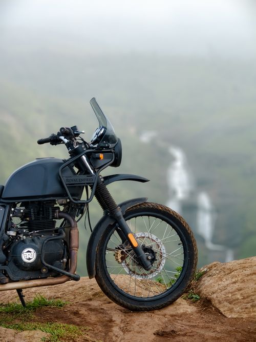Free Adventure bike overlooking a waterfall in Kerala, India, depicting a stunning mountain landscape. Stock Photo