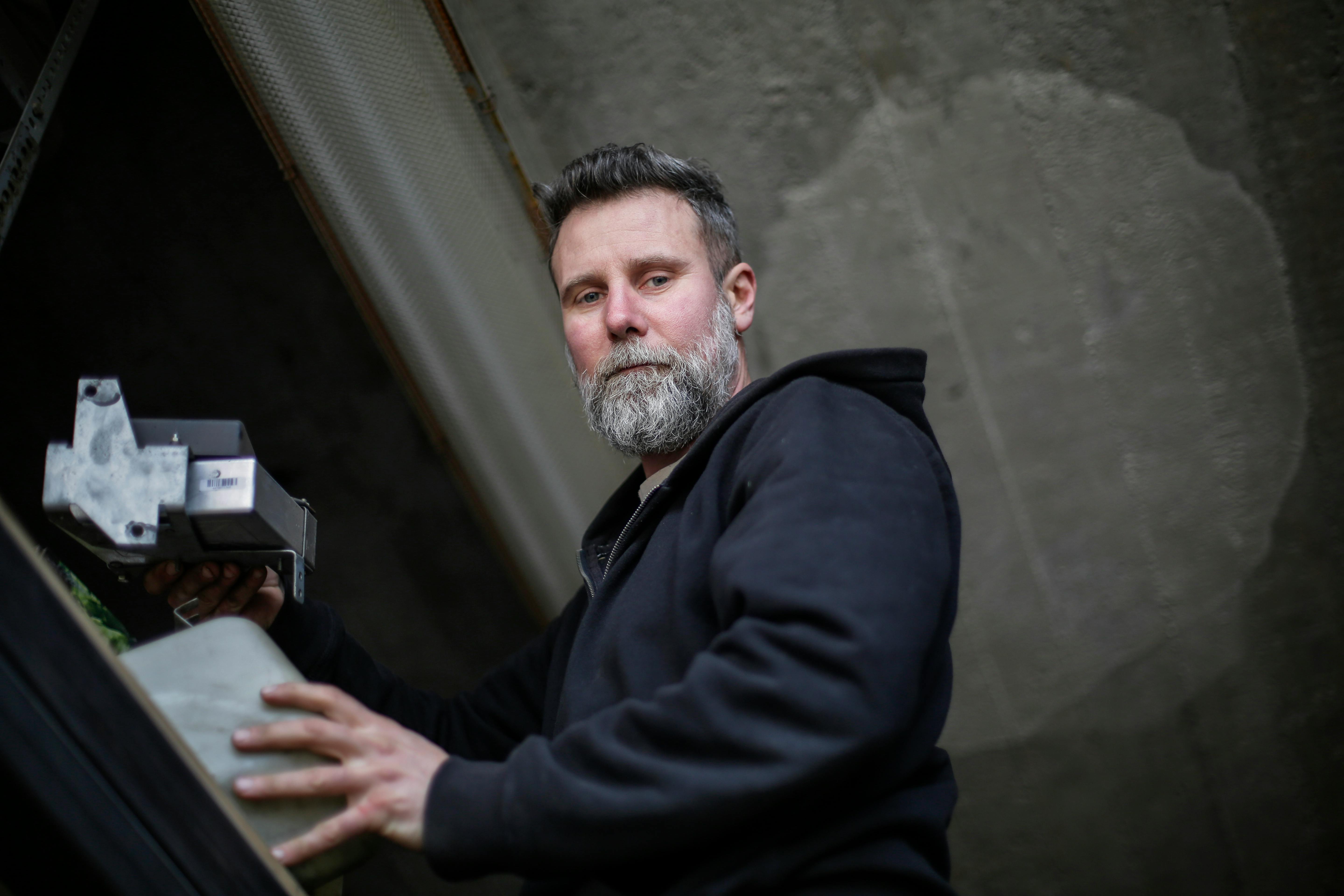 Portrait of a bearded man in an industrial environment, highlighting occupational details.