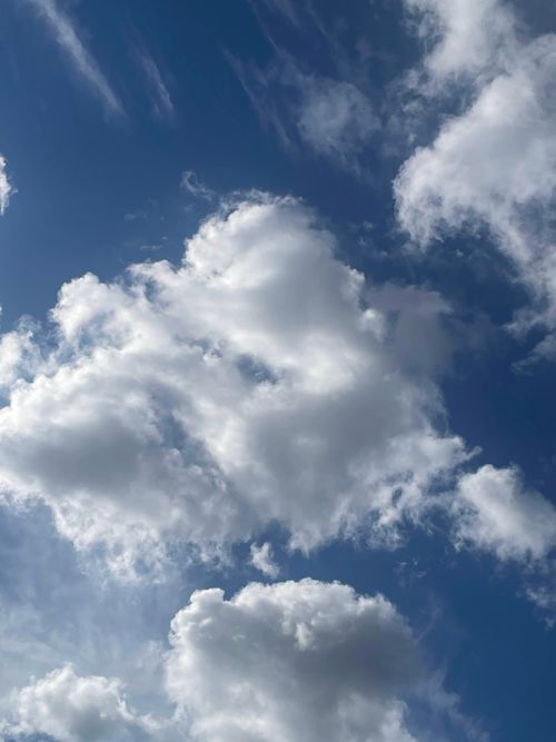 Free Fluffy white cumulus clouds scattered across a deep blue sky, capturing a bright summer day. Stock Photo