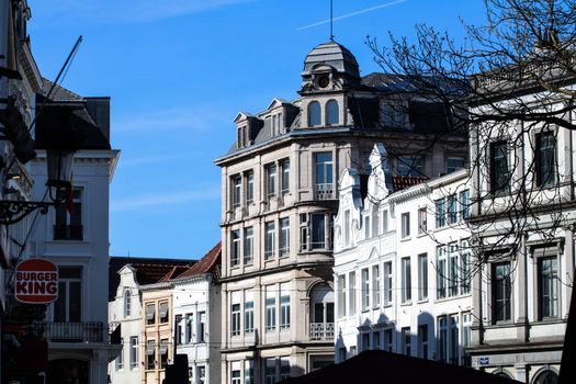 Historic architecture in Brussels with clear blue skies and urban city life.