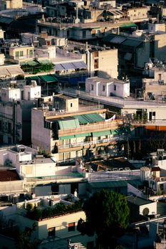 An aerial perspective showcasing densely packed buildings in Athens, Greece during sunset, highlighting urban architecture.