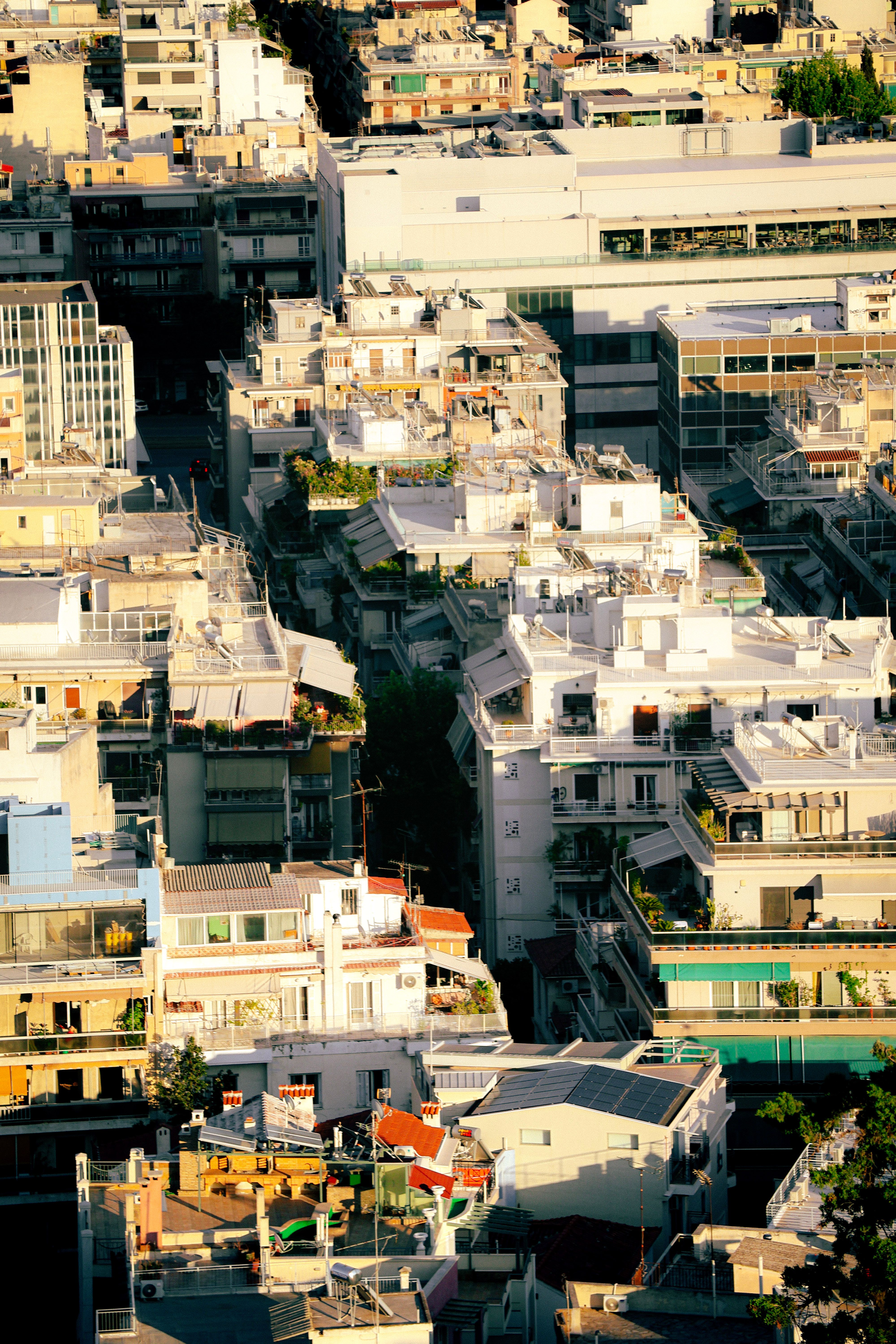 A stunning aerial view of Athens showcasing its urban architecture bathed in sunset light.
