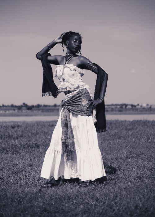 Free Artistic monochrome portrait of a woman posing gracefully in a field, showcasing cultural fashion. Stock Photo