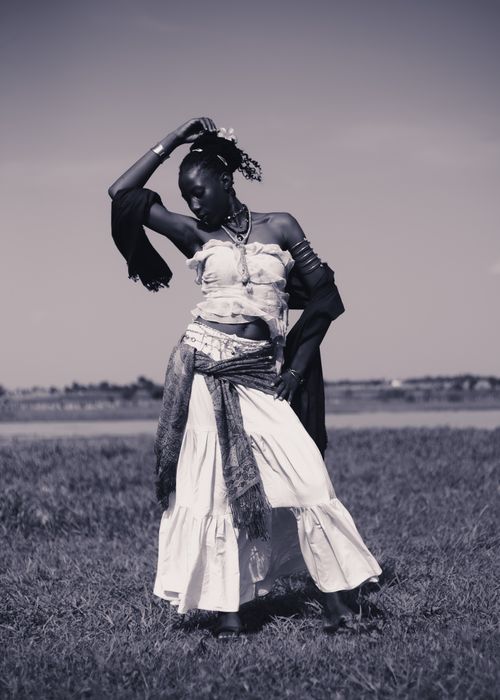 Free Artistic black and white portrait capturing a graceful dancer in traditional attire in an outdoor setting. Stock Photo
