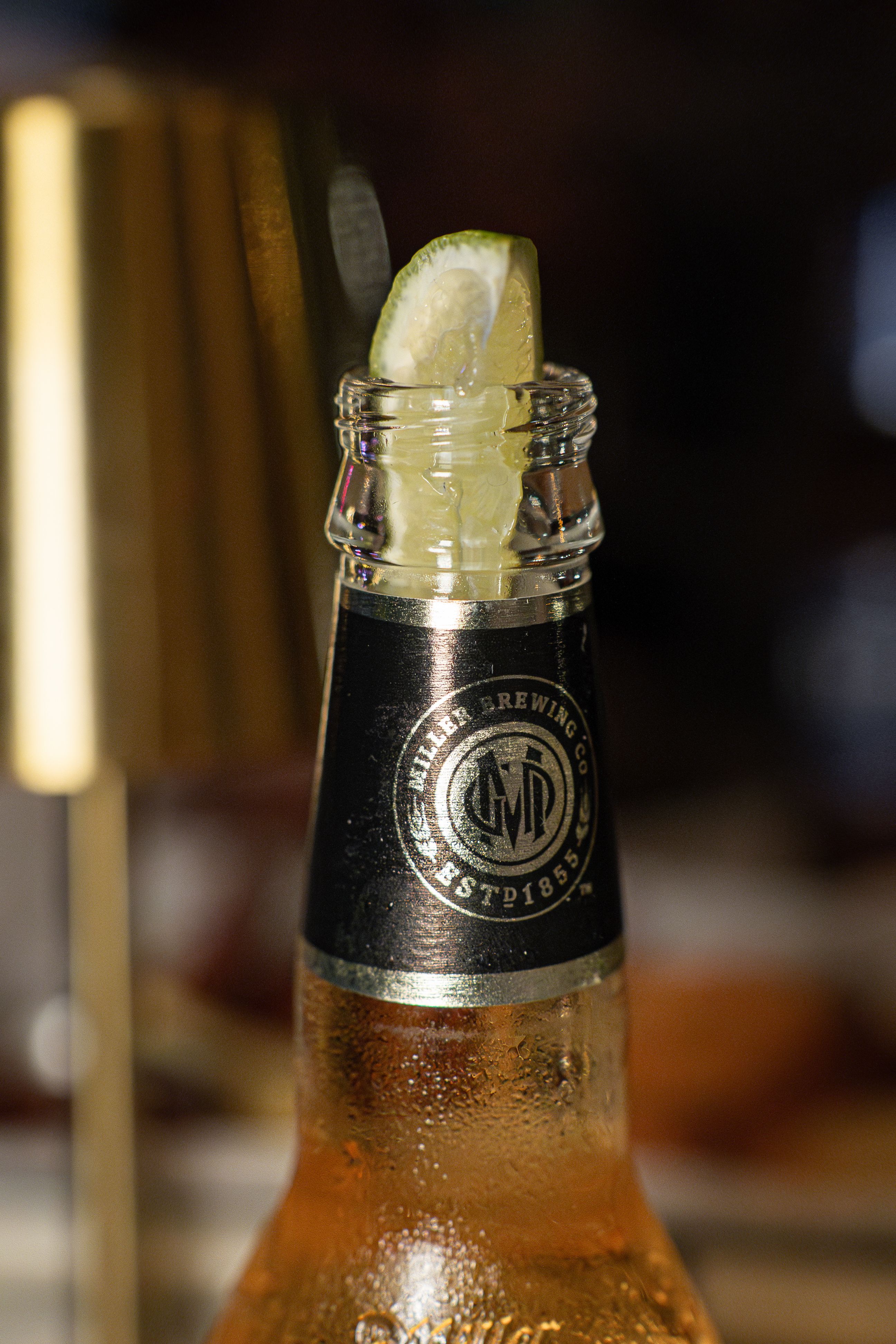 Close-up of a chilled beer bottle with a fresh lime wedge, perfect for summer refreshment.
