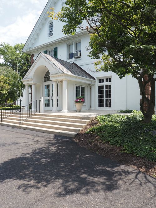 Free Elegant entrance of a historic building in Doylestown, Pennsylvania, surrounded by greenery. Stock Photo