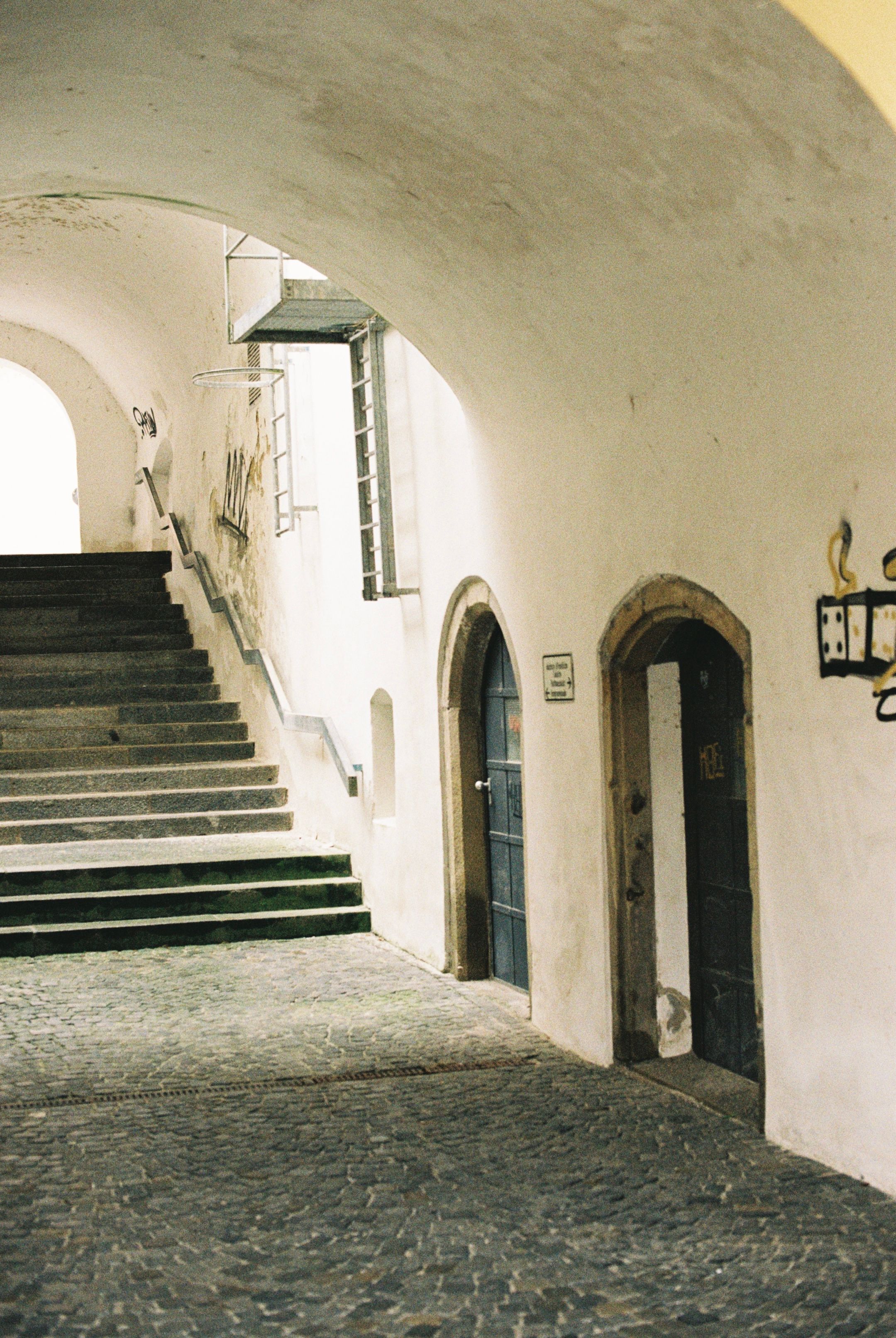 A serene stone stairway and archway in a historic European building.