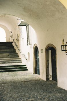 A serene stone stairway and archway in a historic European building.