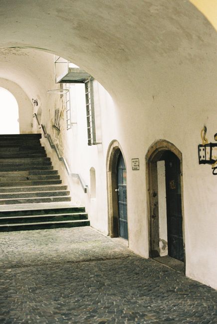 A serene stone stairway and archway in a historic European building.