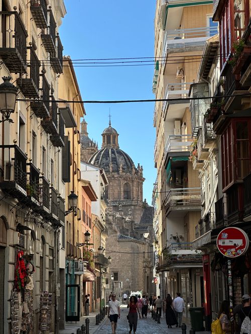 Free Picturesque street in Granada with view of the cathedral dome, showcasing architectural charm. Stock Photo