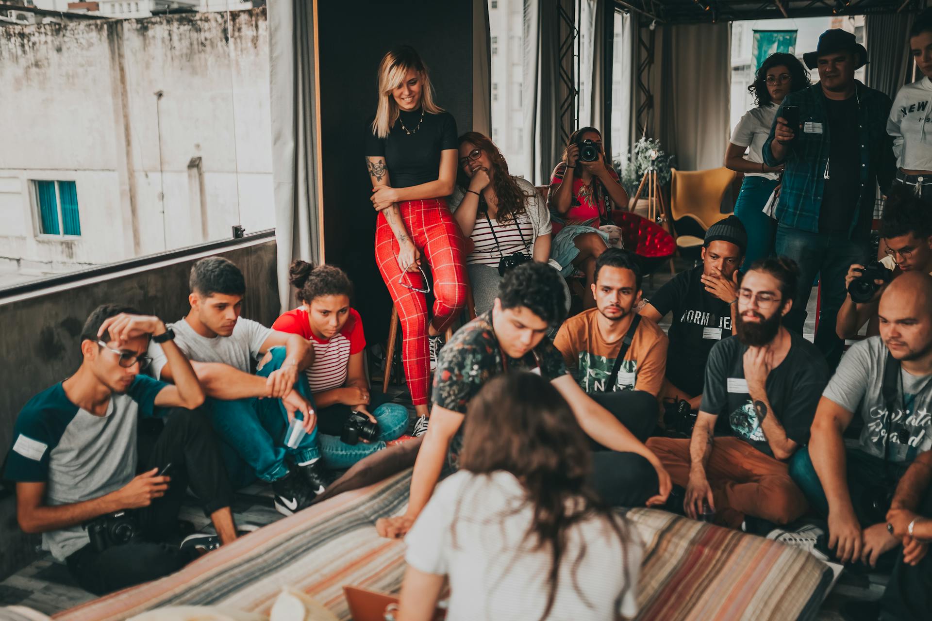 Young adults engaged in a lively group discussion indoors in São Paulo, Brazil.