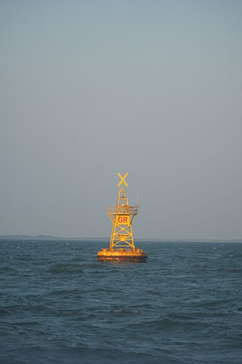 Free A solitary yellow buoy floating on calm sea with clear blue sky in background, Vietnam. Stock Photo
