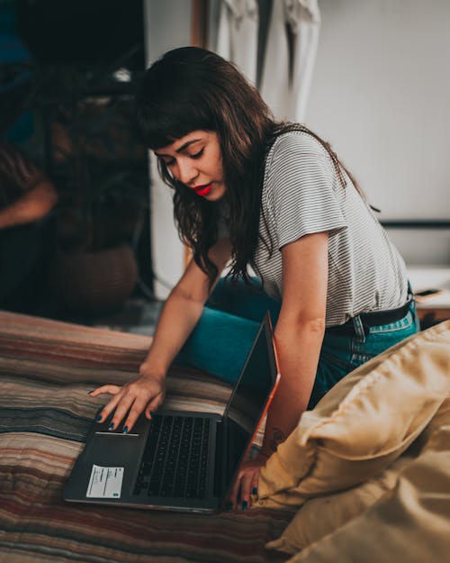 Wanita Yang Menggunakan Laptop Di Atas Tikar Dan Memperagakan Layar