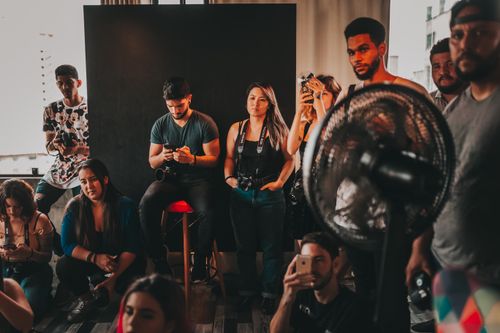 Free Group of young multiracial workers in casual clothes gathering together in modern studio during film making Stock Photo