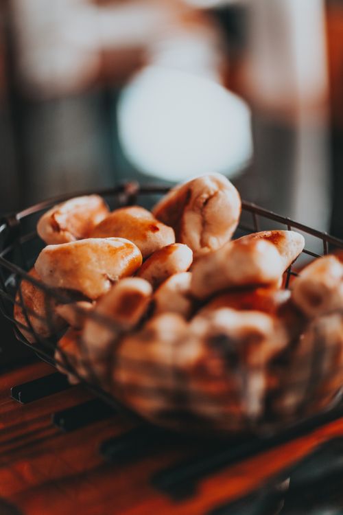 Free From above of metal basket with fresh baked homemade buns placed on table in kitchen Stock Photo