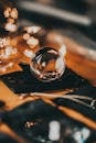 High angle of transparent glass ball placed on gift sack and reflecting lights of glowing garland