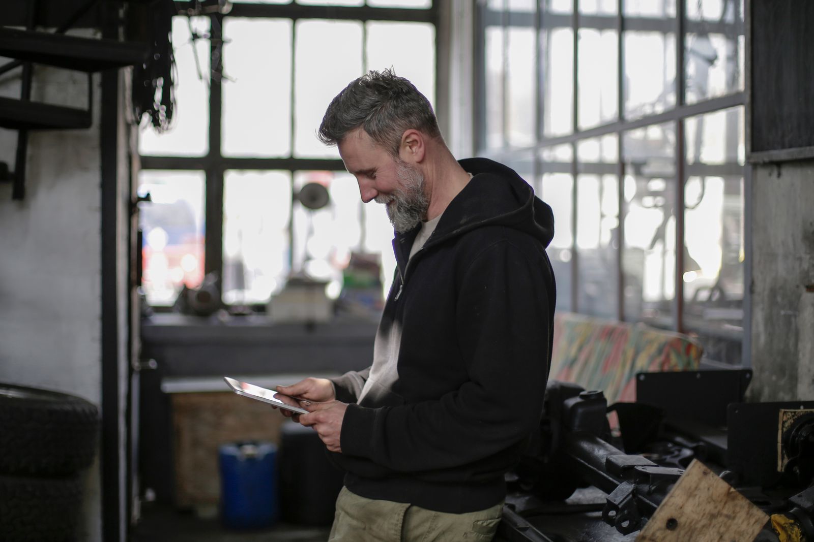 Technicien concentré sur son tablette numérique dans l'atelier