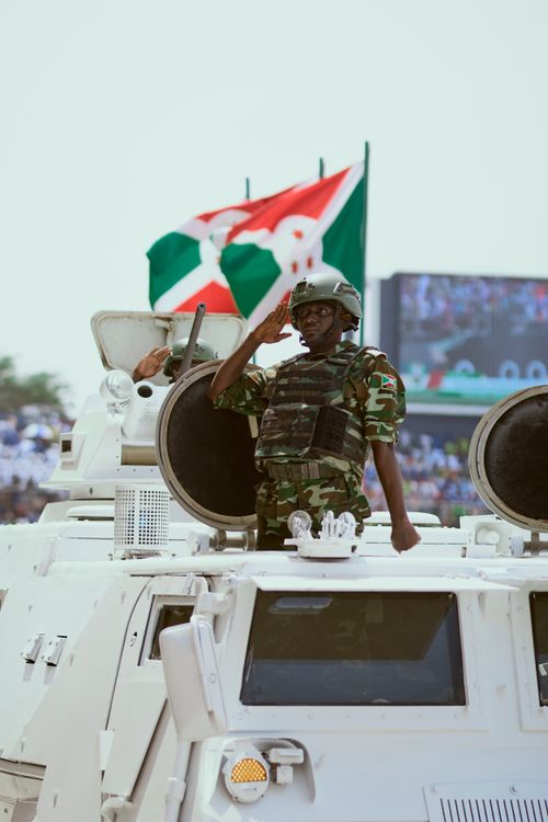 Free Burundian soldier saluting from an armored vehicle during a national parade. Stock Photo