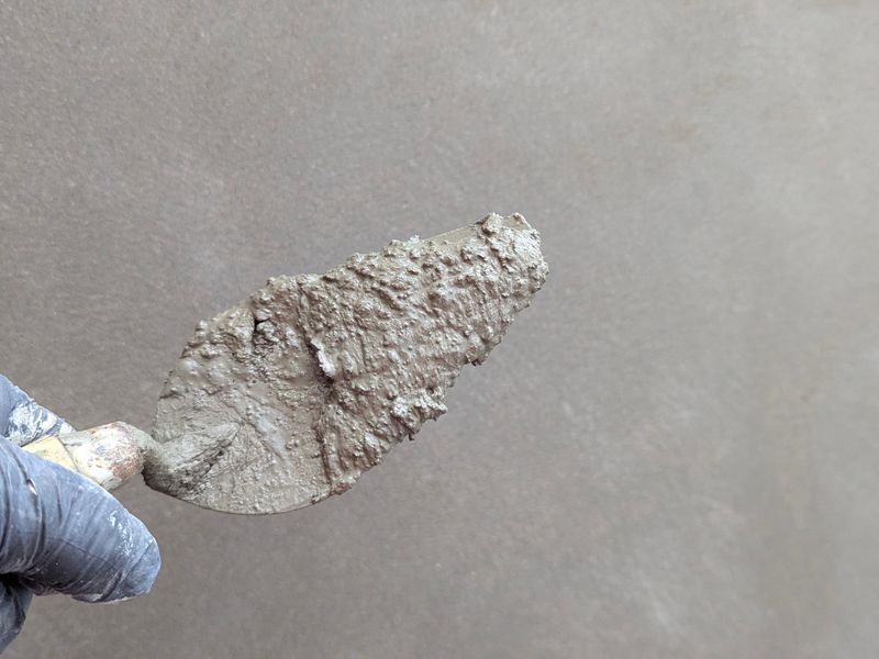 Render being applied to a wall with a trowel