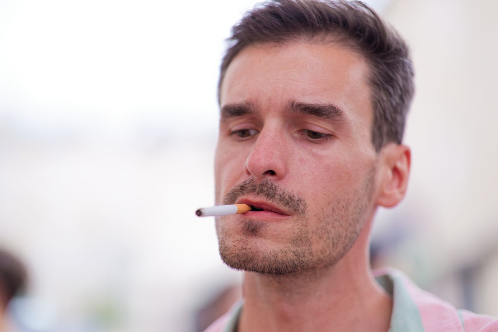 Profil d'un homme fumant une cigarette sous une lumière douce