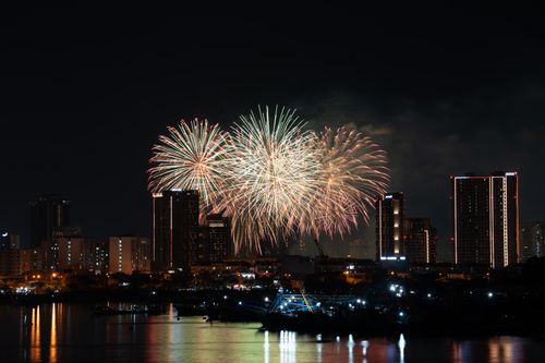Free Colorful fireworks explode over a cityscape at night, creating a stunning visual spectacle. Stock Photo