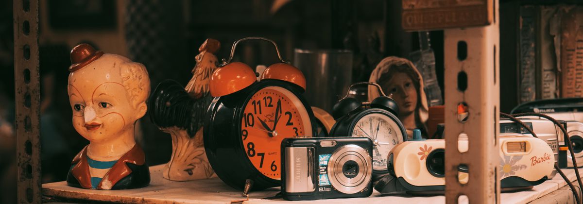 A shelf of vintage collectibles and clocks