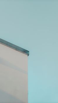 A minimalist photo capturing a building wall against a clear sky, emphasizing simplicity and geometry.