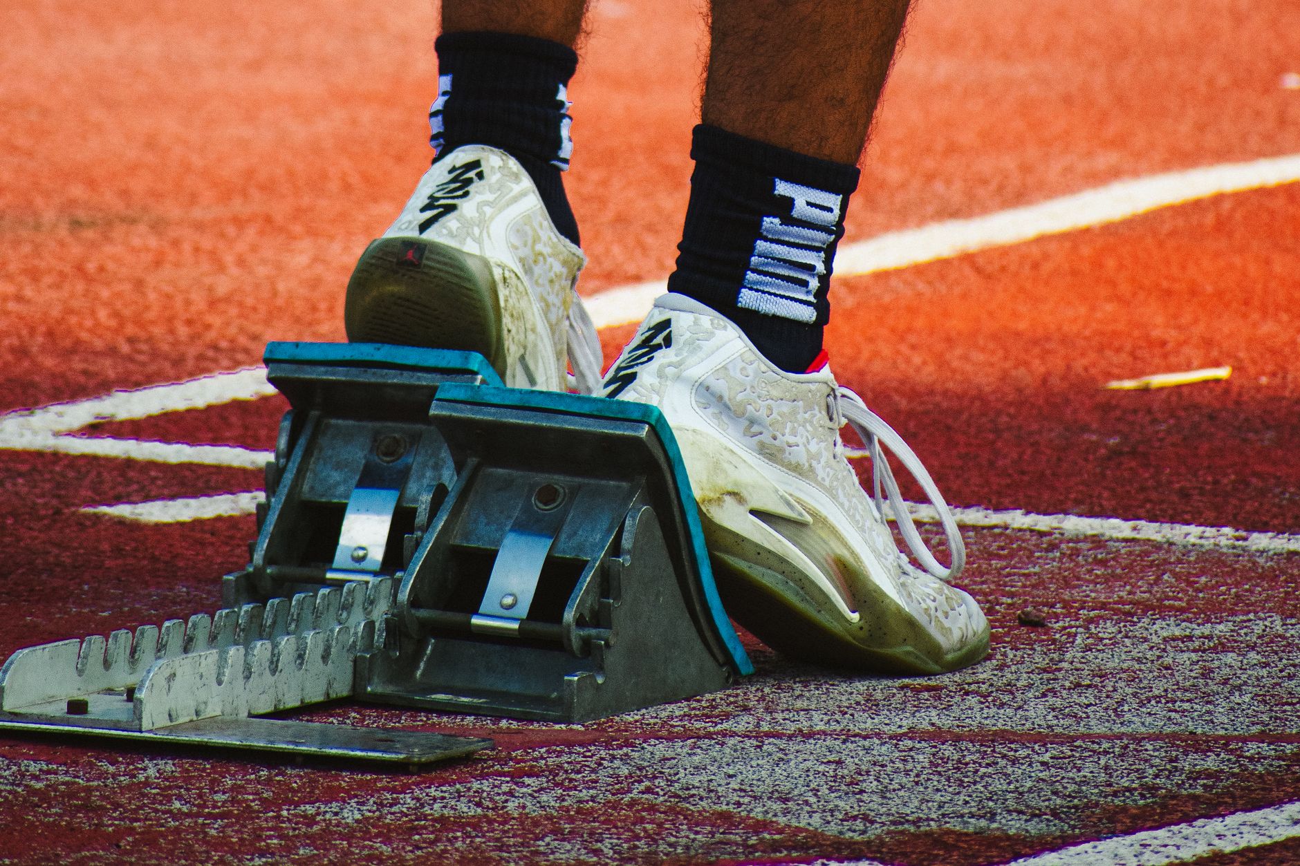 Puma Future 8 Play cleats being laced by a beginner near an indoor football training facility
