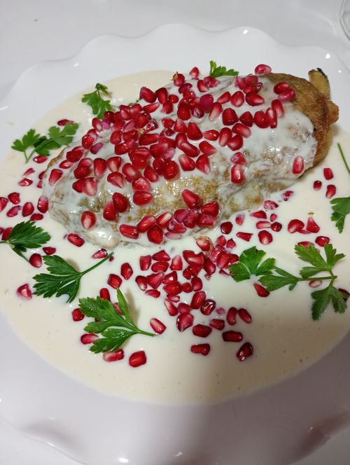Free Traditional Chiles en Nogada dish garnished with fresh pomegranate seeds and parsley. Stock Photo