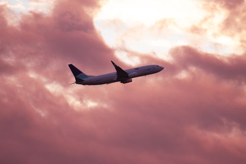 Free Airplane silhouetted against a dramatic pink sunset sky in Gothenburg, Sweden. Stock Photo